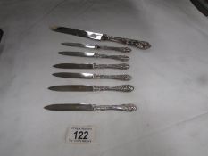 6 decorative silver handled fruit knives and a silver handled table knife.