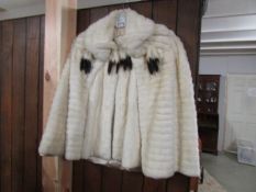 A white fur cape, possibly ermine, with label 'Ben M Cohen Finefure inc.