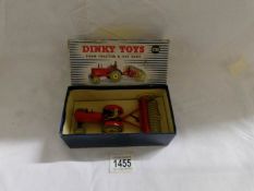 A boxed Dinky farm tractor and rake.