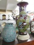 A large glazed stoneware vase and one other on an alabaster stand.