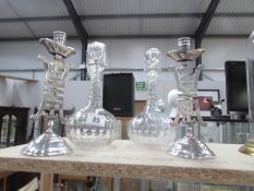 A pair of Chinese style candlesticks and a pair of glass decanters with stoppers.