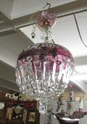 A vintage chandelier in cranberry and clear glass.