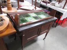 A marble topped washstand with tiled back.