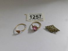 A gold ring with pink stone marked 9ct, a yellow metal ring a/f and a Boy's Brigade badge.