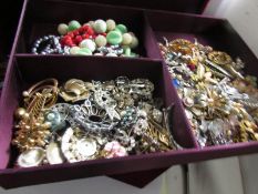 A large red velvet box containing a quantity of costume jewellery.