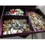 A large red velvet box containing a quantity of costume jewellery.