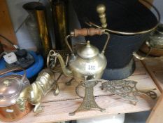 A shelf of brassware including kettle on stand, coal bucker, copper kettle etc.
