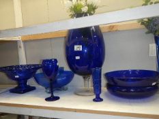 A shelf of blue glass ware.