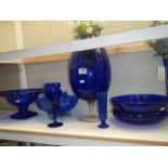 A shelf of blue glass ware.