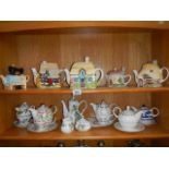 2 shelves of tea ware including teapots.