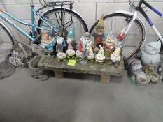 A large collection of garden items including small stone bench, planters, statues,