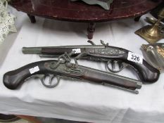 A pair of ornamental flintlock pistols.