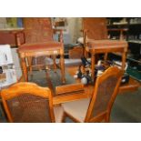 An extending dining table and set of 6 cane backed chairs.