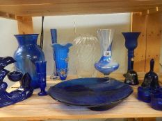 A shelf of blue glass ware.