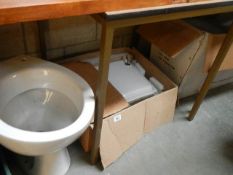 A new modern wash basin and 2 toilets.