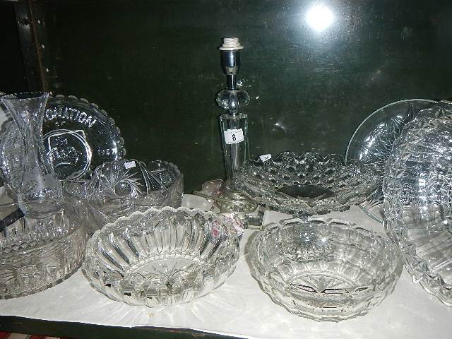 A shelf of glassware including bowls, commemorative plates, cake stand etc.
