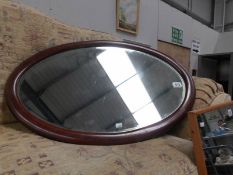 An oval framed bevel edged mirror.