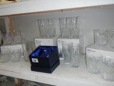 A shelf of boxed glass tumblers.