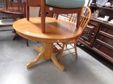 A circular oak table and one chair,