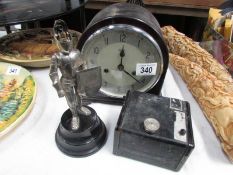 A Smith's mantel clock, a Kodak Brownie camera and a musical lighter in the form of a knight.