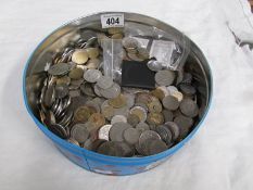 A tin of mixed English and foreign coins.