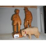 2 wooden figures and a wooden cow.