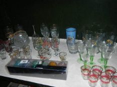 A shelf of assorted drinking glasses including retro.