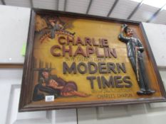 A wooden Charlie Chaplin wall plaque.