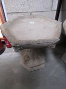 A Gothic style bird bath with hexagonal top.