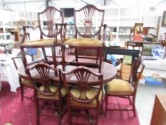 A mahogany extending dining table and 8 shield back dining chairs.