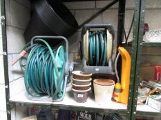 A shelf of hose pipes, garden pots. etc.