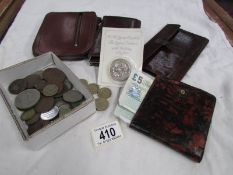 A mixed lot of leather purses, wallets, coins and bank notes.