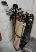 3 old golf bags with various clubs.