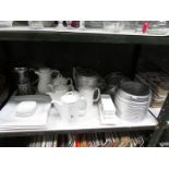 A shelf of assorted hotel ware including teapots etc.