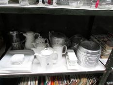 A shelf of assorted hotel ware including teapots etc.