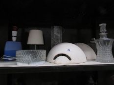 A shelf of assorted lighting and glass ware.