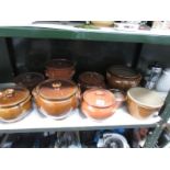 A shelf of stoneware cooking pots.