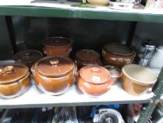 A shelf of stoneware cooking pots.