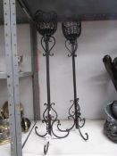 A pair of tall metal candlesticks.