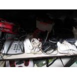 A shelf of assorted telephones,
