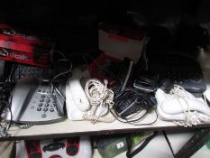 A shelf of assorted telephones,