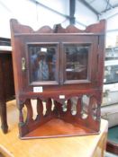 A small Edwardian dark wood stained corner cabinet.