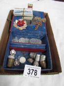 A small jewellery box and contents including repro coins, thimbles, jewellery etc.