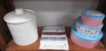 A bread crock, a set of 3 cake tins and a pack of new teatowels.