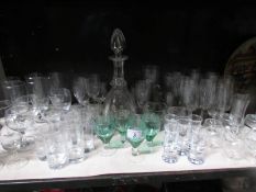A shelf of glass ware including decanter.