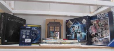 A shelf of Doctor Who collectable's including Tardis lidded mug, set of 4 mugs, jigsaw puzzles,