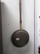A Victorian copper warming pan.
