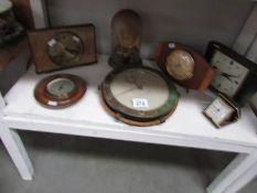 A shelf of vintage/retro clocks and a barometer.