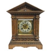 An oak cased mantel clock with brass face, mechanism marked 'Unghans J'.