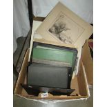 A box of old photographs, loose and in albums.